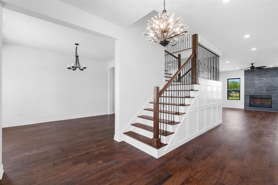Staircase with a chandelier, hardwood / wood-style flooring, recessed lighting, a fireplace, and ceiling fan Staircase with a chandelier, hardwood / wood-style flooring, recessed lighting, a fireplace, and ceiling fan