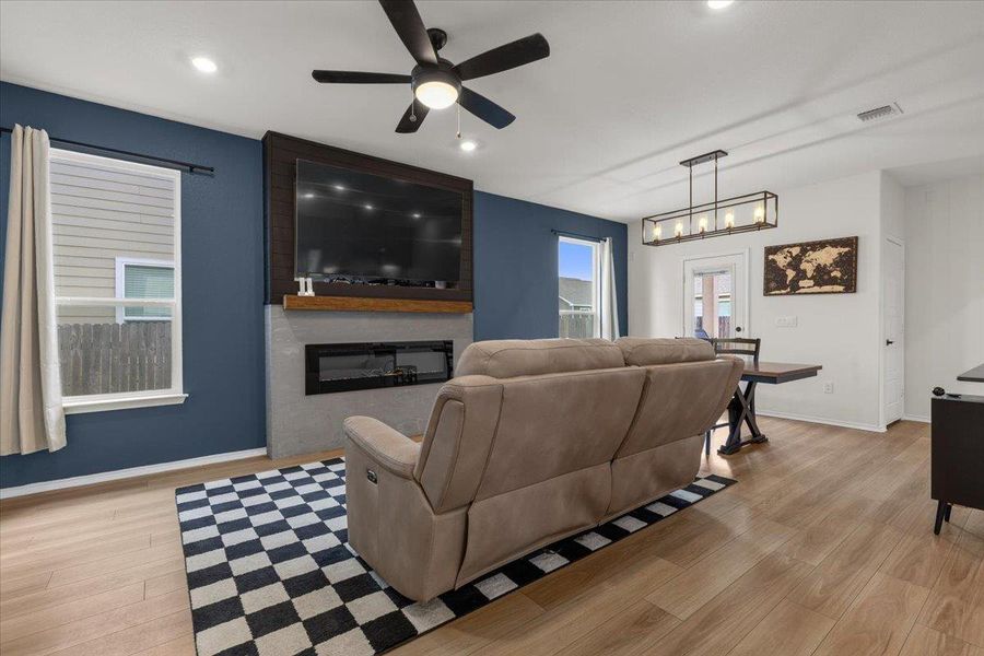 A contemporary living area presents a sleek fireplace, durable flooring, and ample natural light.