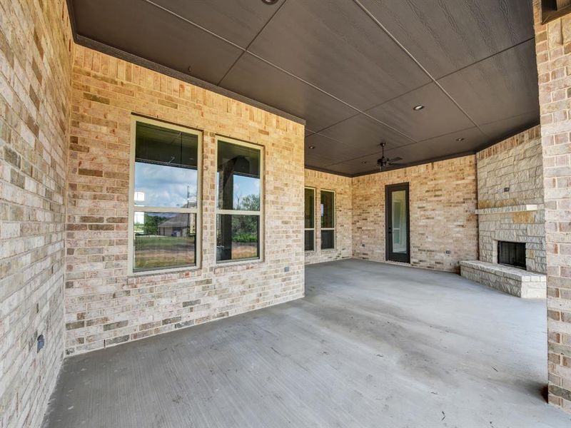 View of patio with an outdoor stone fireplace and ceiling fan