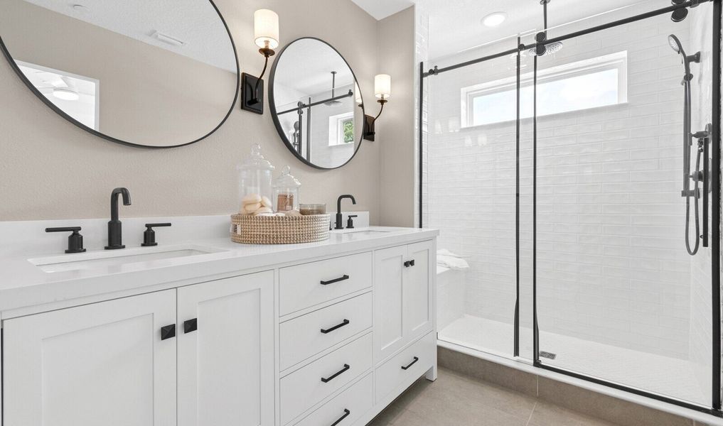 Primary bath with freestanding vanity and glass shower enclosure Primary bath with freestanding vanity and glass shower enclosure