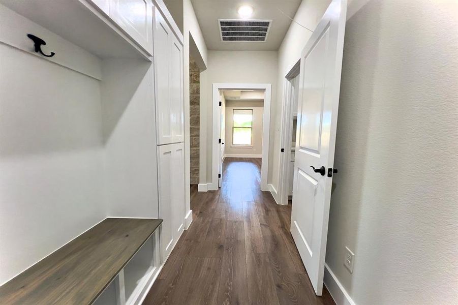 Mudroom with dark flooring and baseboards