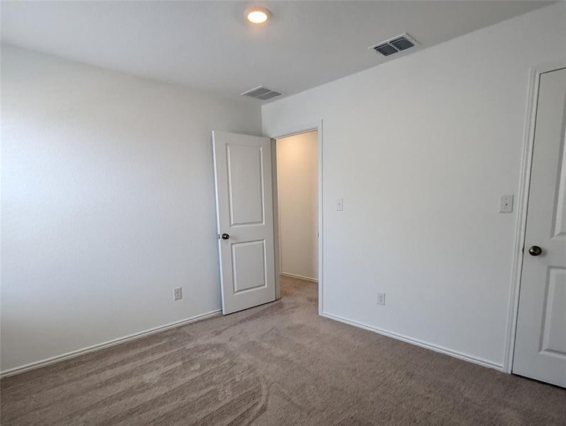 A well-proportioned interior space offers a neutral palette and plush carpeting.