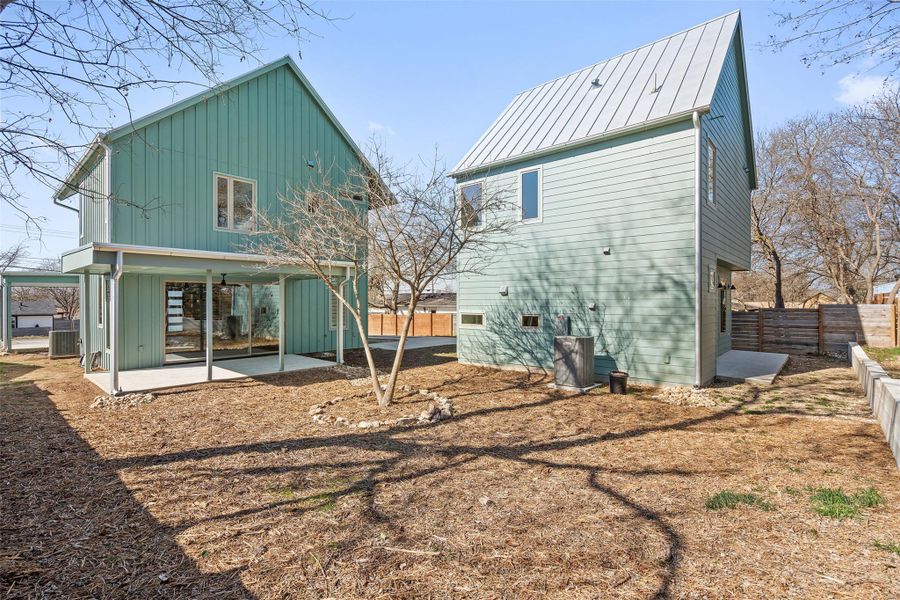 Rear view of property with a patio, a standing seam roof, central AC, metal roof, and a fenced backyard