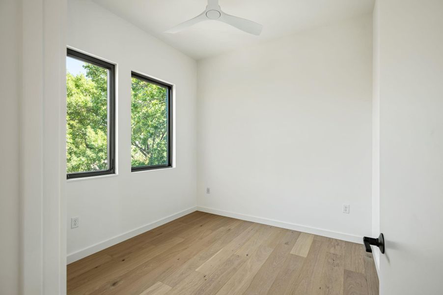 Natural light pours over warm hardwood floors in this minimalist space.