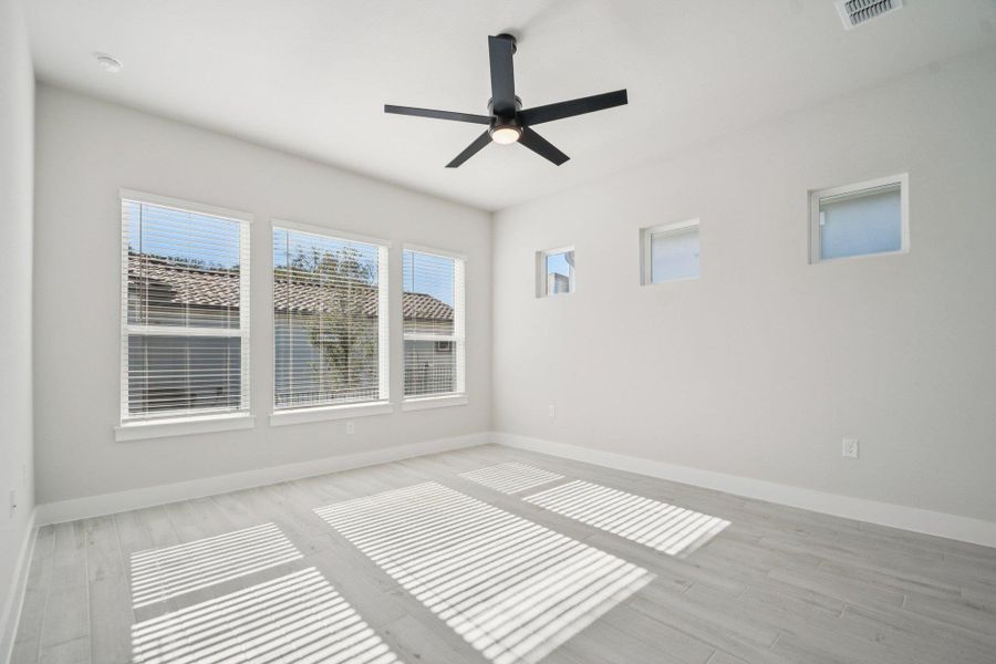 Empty room with light wood-type flooring and ceiling fan