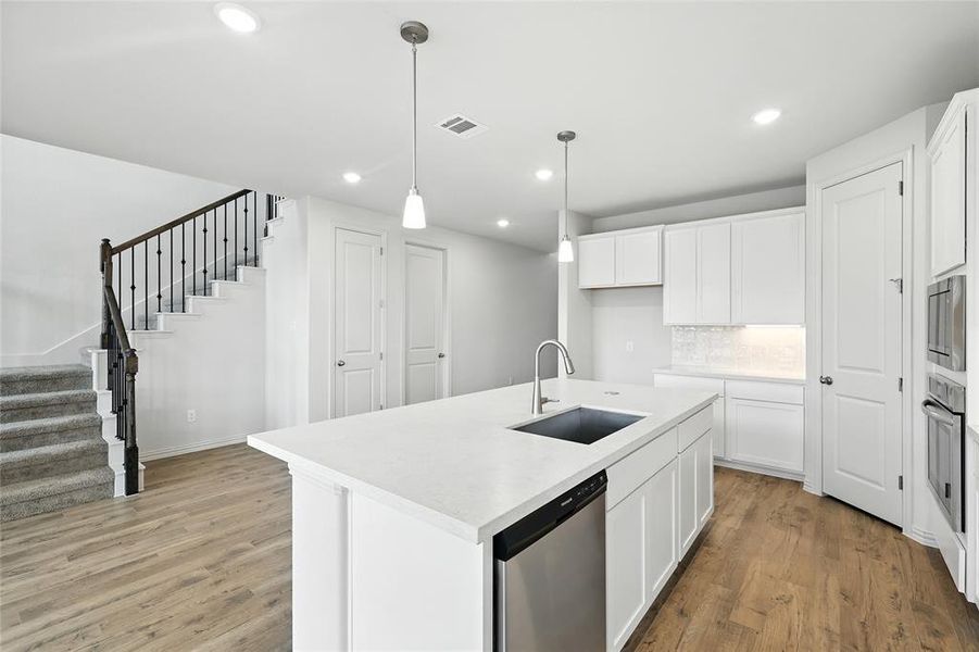 Kitchen featuring light wood-style flooring, stainless steel appliances, white cabinetry, and recessed lighting
