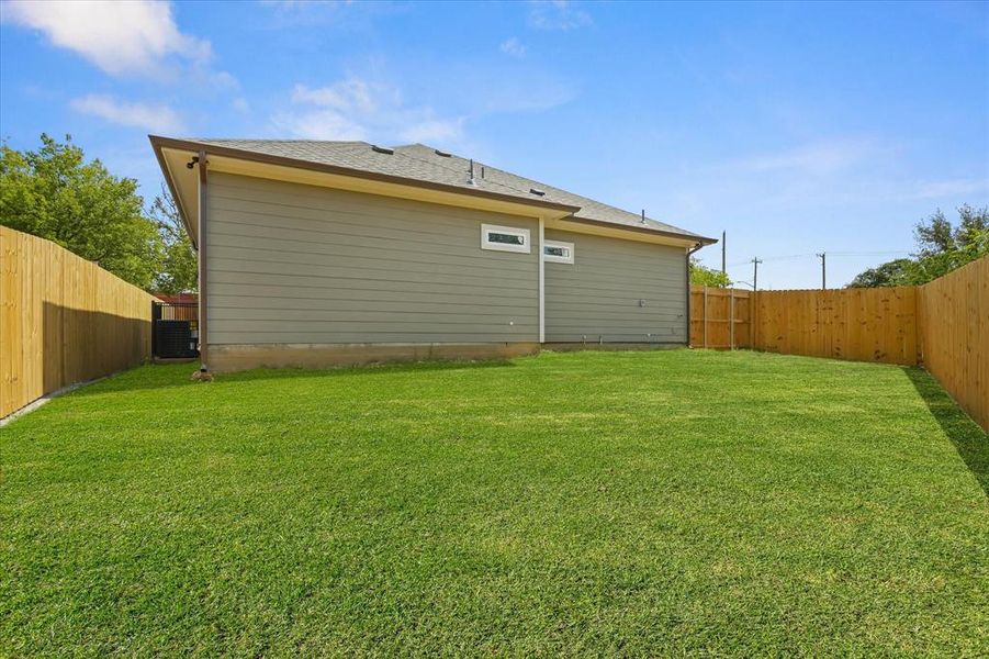 Rear view of house featuring a fenced backyard and a shingled roof Rear view of house featuring a fenced backyard and a shingled roof