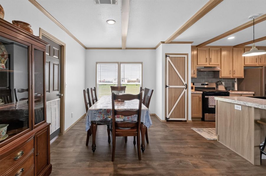 This naturally illuminated open-concept dining area seamlessly connects to a contemporary kitchen, ideal for effortless entertaining.