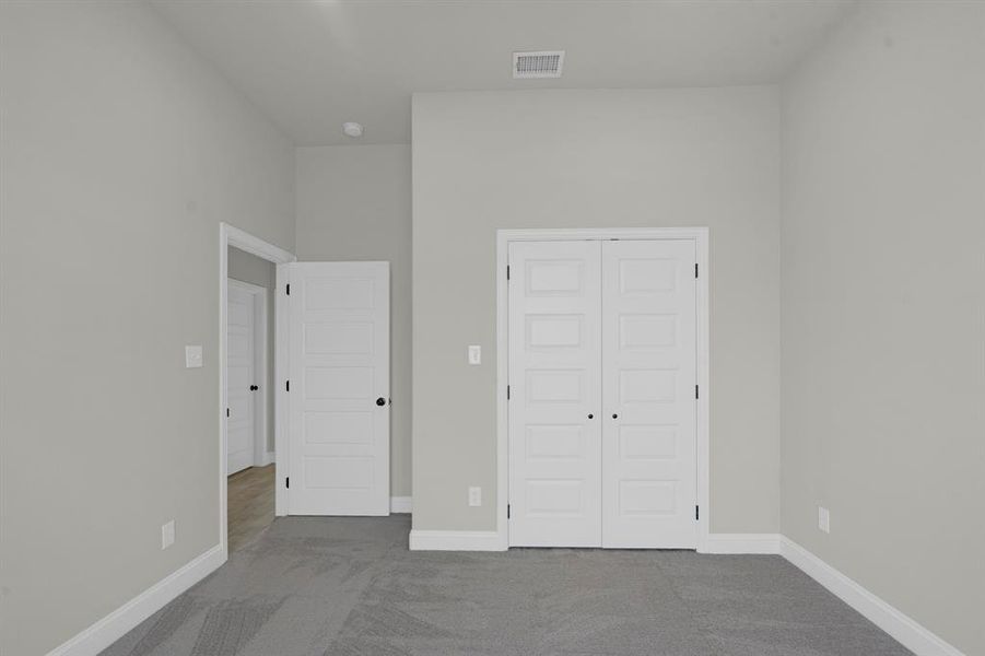 Unfurnished bedroom featuring a closet and light colored carpet