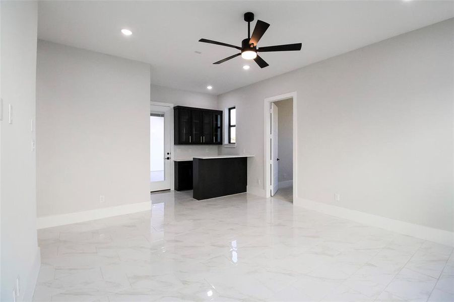 Unfurnished living room featuring ceiling fan