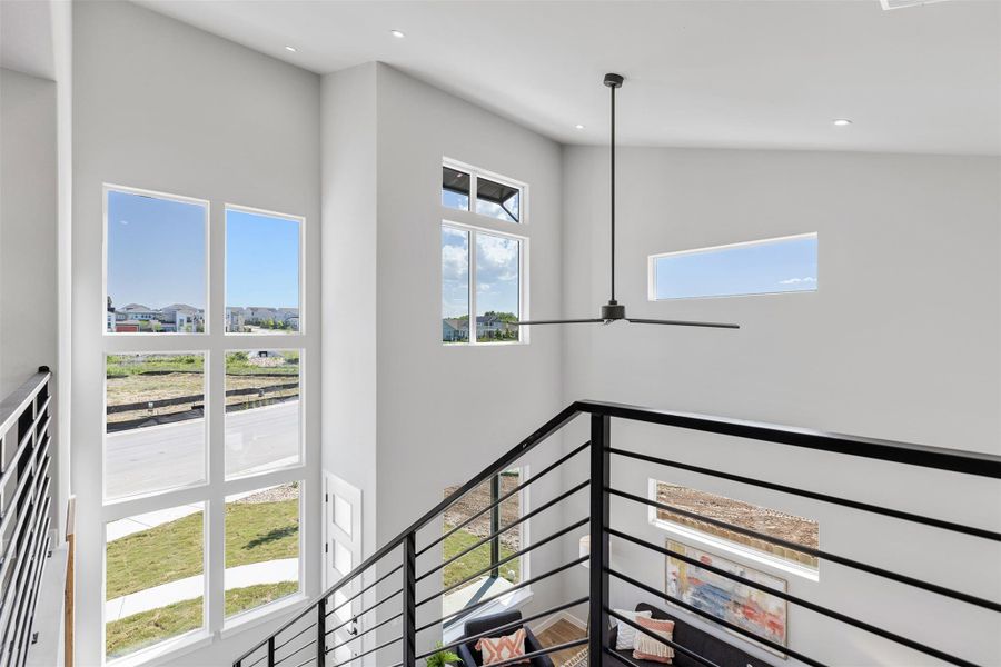 Stairway with a high ceiling, a ceiling fan, and recessed lighting