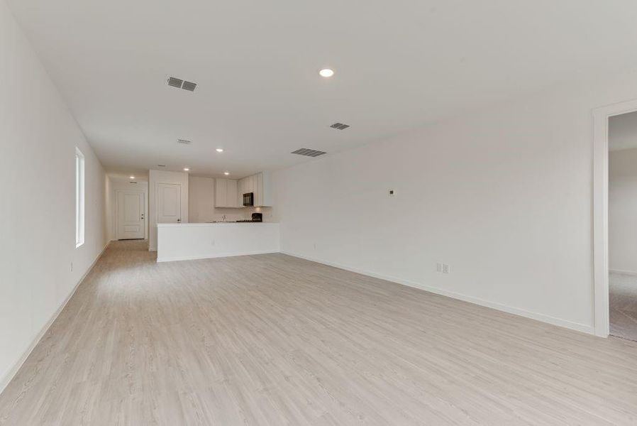 Unfurnished living room with recessed lighting, visible vents, light wood-style flooring, and baseboards