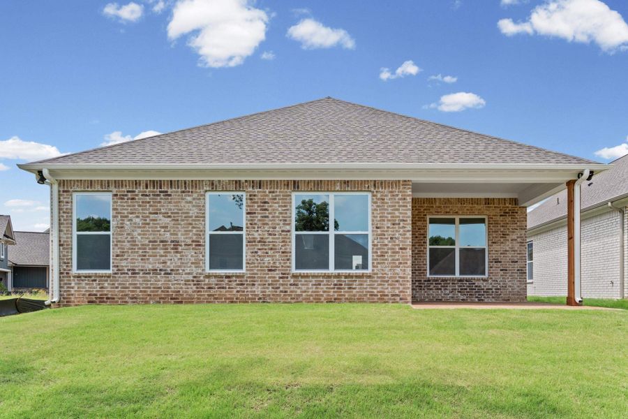 Brick exterior featuring a covered patio, multiple windows, and a shingle roof Brick exterior featuring a covered patio, multiple windows, and a shingle roof