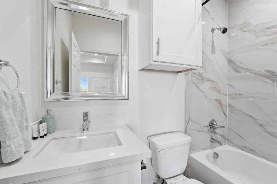 The primary bathroom is beautifully finished with contemporary fixtures, sleek tile surrounds, and a clean, modern design that feels both stylish and functional.