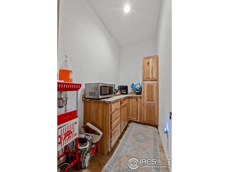 Spacious walk-in pantry with custom wood cabinetry and ample storage, perfect for keeping kitchen essentials organized and within easy reach.