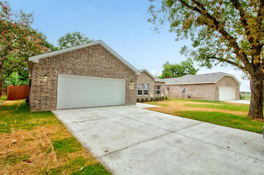 View of front of home with brick siding, concrete driveway, and a garage View of front of home with brick siding, concrete driveway, and a garage