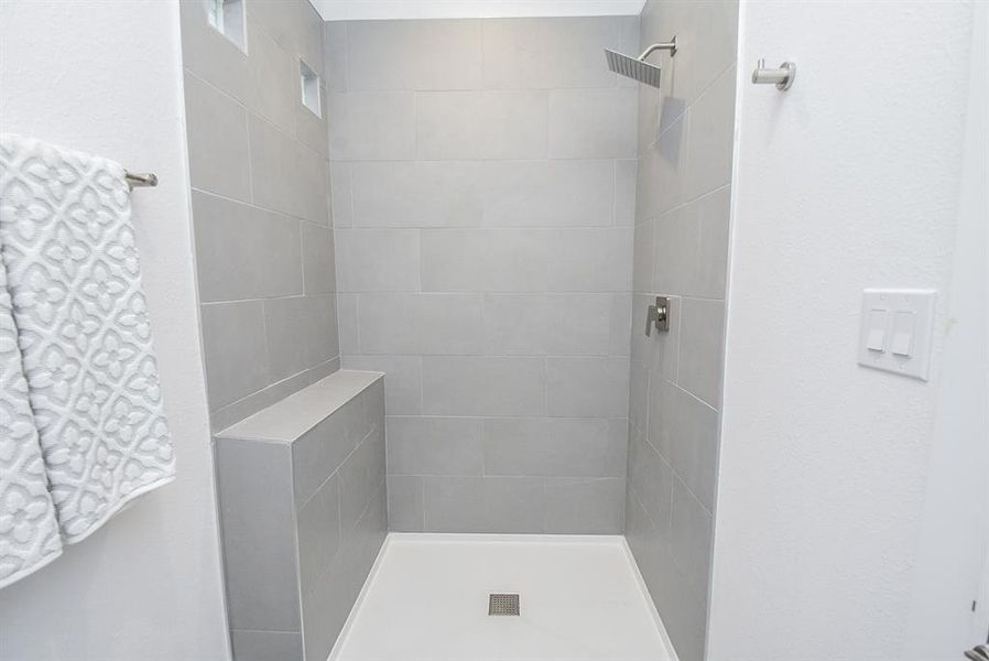 You'll enjoy this roomy walk-in shower in the secondary bath. (Note the charming 'tiny' windows, up left.)