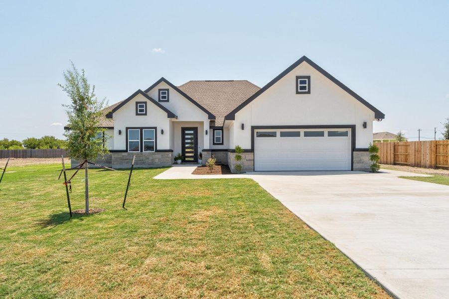 Modern farmhouse style home with stone siding, concrete driveway, stucco siding, and a garage Modern farmhouse style home with stone siding, concrete driveway, stucco siding, and a garage