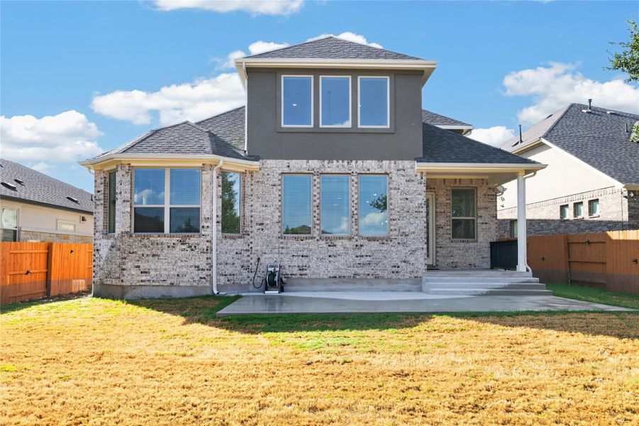 Clean architectural lines define the brick exterior of this modern home with a back patio. Clean architectural lines define the brick exterior of this modern home with a back patio.