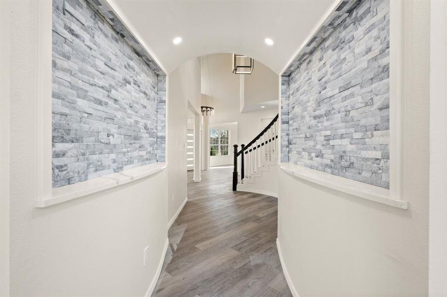 Corridor featuring lofted ceiling, wood finished floors, and recessed lighting Corridor featuring lofted ceiling, wood finished floors, and recessed lighting
