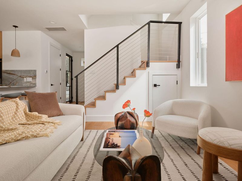 Living area featuring wood finished floors and stairway Living area featuring wood finished floors and stairway