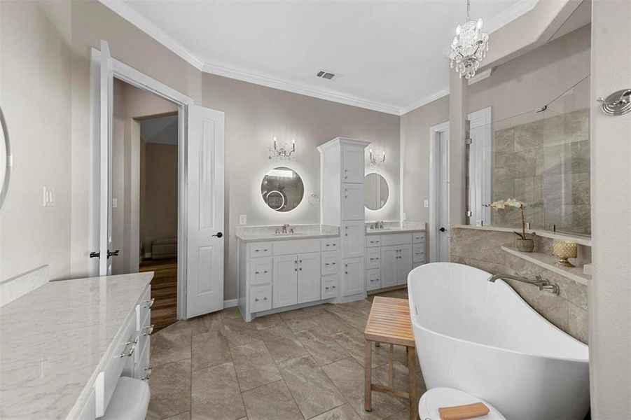 Bathroom with vanity, a bath, crown molding, and a chandelier