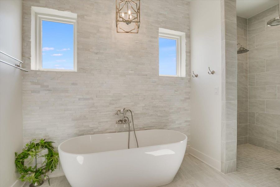 Bathroom featuring healthy amount of natural light, a soaking tub, and tiled shower Bathroom featuring healthy amount of natural light, a soaking tub, and tiled shower