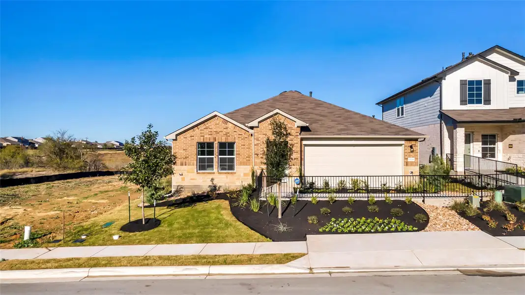 Front exterior of a new home in Carillon, Manor, TX, highlighting curb appeal (Image 21).
