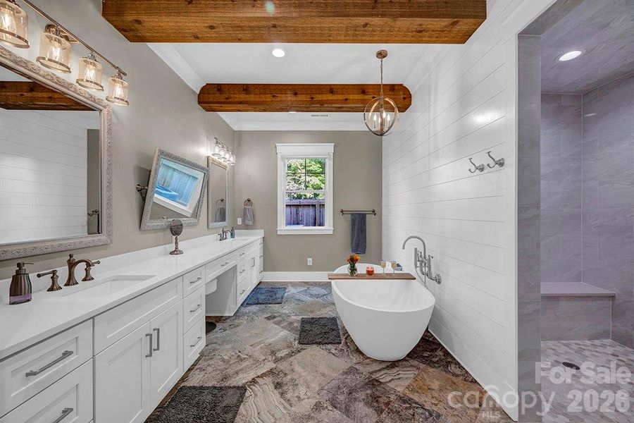 Main Level Primary Suite bathroom; oversized oval soaking tub and frameless steam shower.