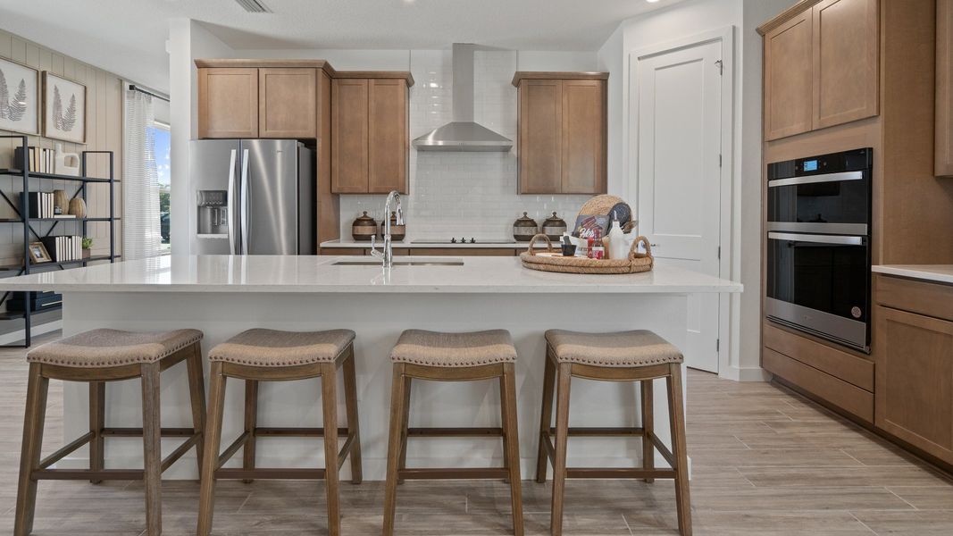 Kitchen with large island and and corner pantry in a DRB Home Clementine model at the Trinity Place community.