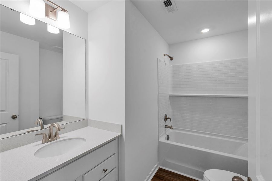 This bright bathroom features a vanity with ample