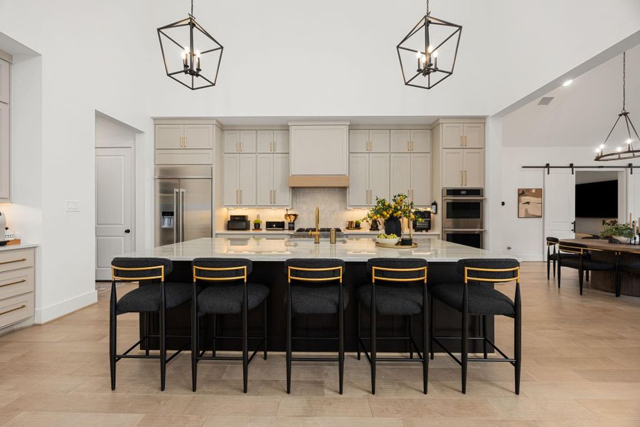 This kitchen has it all! A large island with seating, stainless steel appliances, and ample cabinetry. The open layout seamlessly connects to the dining area and breakfast area, perfect for entertaining.