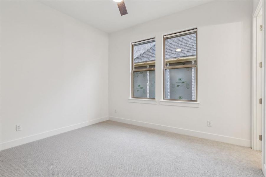 Carpeted spare room featuring ceiling fan