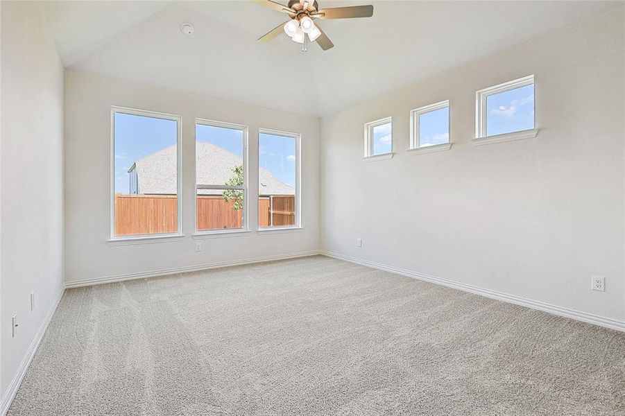 Unfurnished room with ceiling fan, lofted ceiling, and light carpet