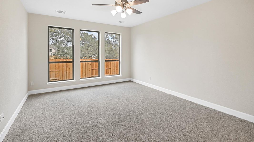 Empty room featuring carpet flooring and a ceiling fan
