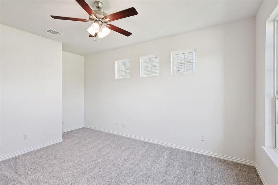 Carpeted spare room with ceiling fan