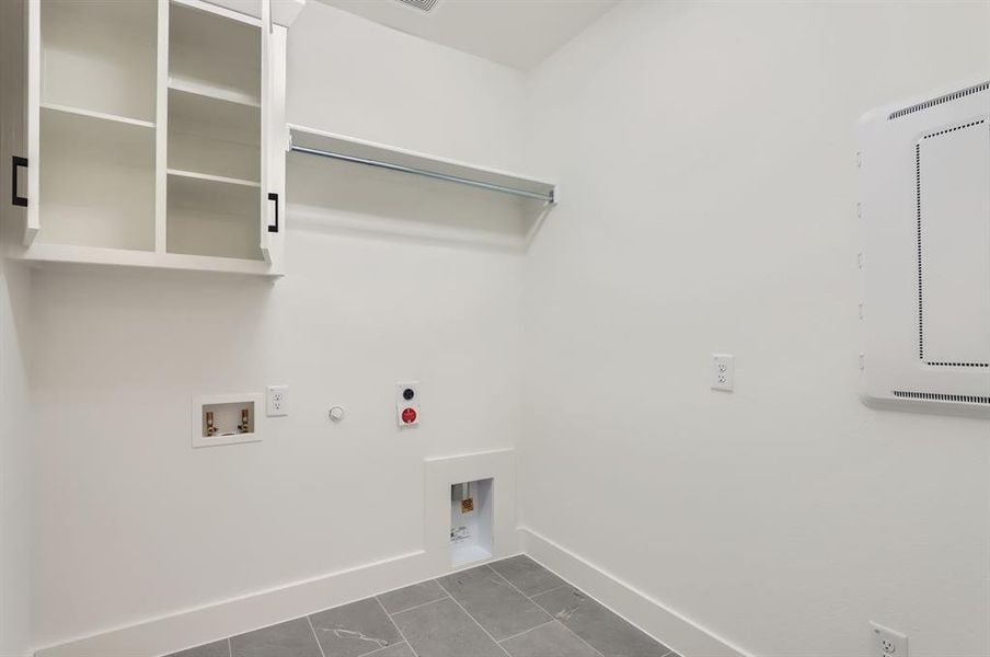 Clothes washing area featuring electric dryer hookup, hookup for a gas dryer, hookup for a washing machine, and dark tile patterned floors