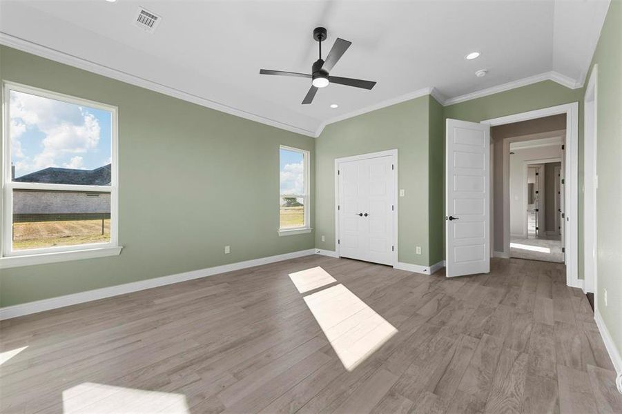 Second living or 4th  bedroom with ceiling fan, ornamental molding, and light wood-type flooring