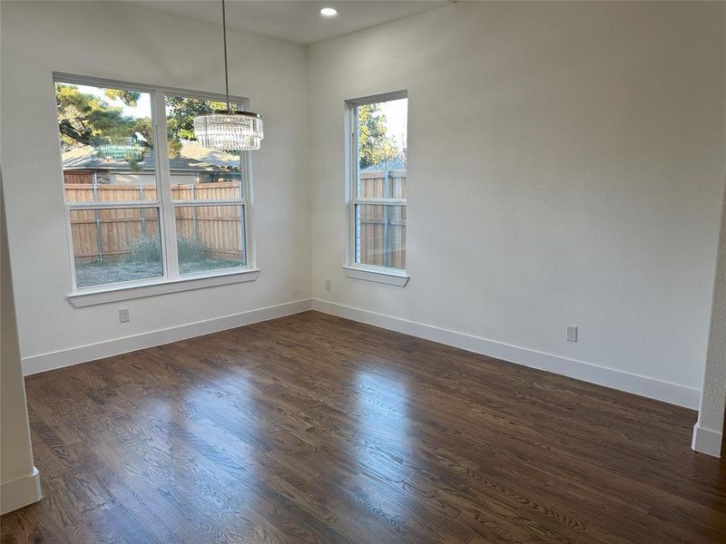 Unfurnished dining area with dark hardwood / wood-style floors and a chandelier