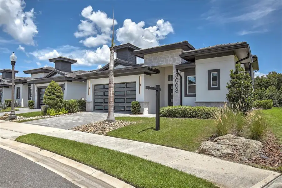 Front exterior of a new home in Hampton Green at Providence, Davenport, FL, highlighting curb appeal (Image 2). Front exterior of a new home in Hampton Green at Providence, Davenport, FL, highlighting curb appeal (Image 2).