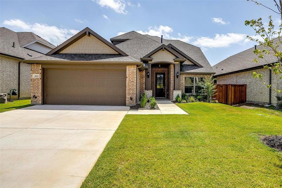 View of front of house featuring a garage and a front yard