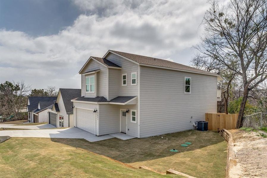 View of home's exterior with roof with shingles, an attached garage, and driveway