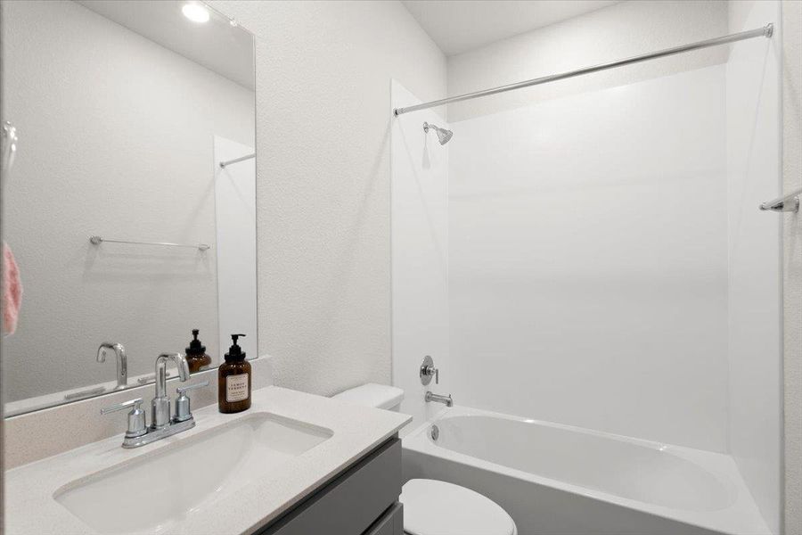 Contemporary bathroom featuring a chrome faucet, integrated sink, and light-toned countertop