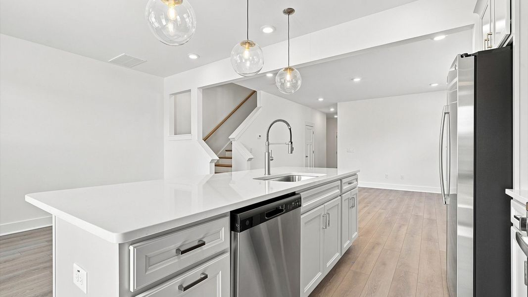 Superior craftsmanship shines in this modern kitchen with a space-saving island and open flow by DRB Homes Superior craftsmanship shines in this modern kitchen with a space-saving island and open flow by DRB Homes