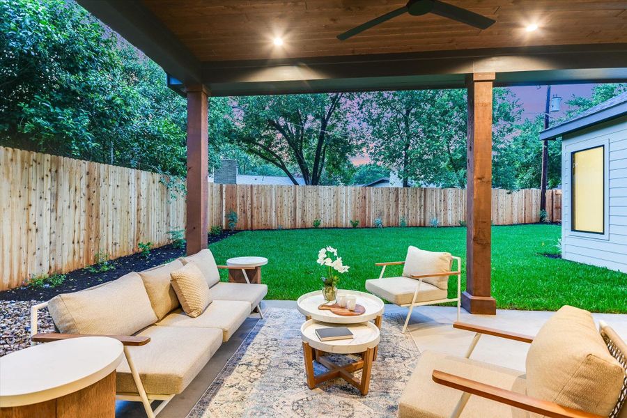 An inviting covered patio with a wooden ceiling, recessed lighting, and a ceiling fan - overlooking the lush green lawn, enclosed by a 7'-tall privacy fence. An inviting covered patio with a wooden ceiling, recessed lighting, and a ceiling fan - overlooking the lush green lawn, enclosed by a 7'-tall privacy fence.