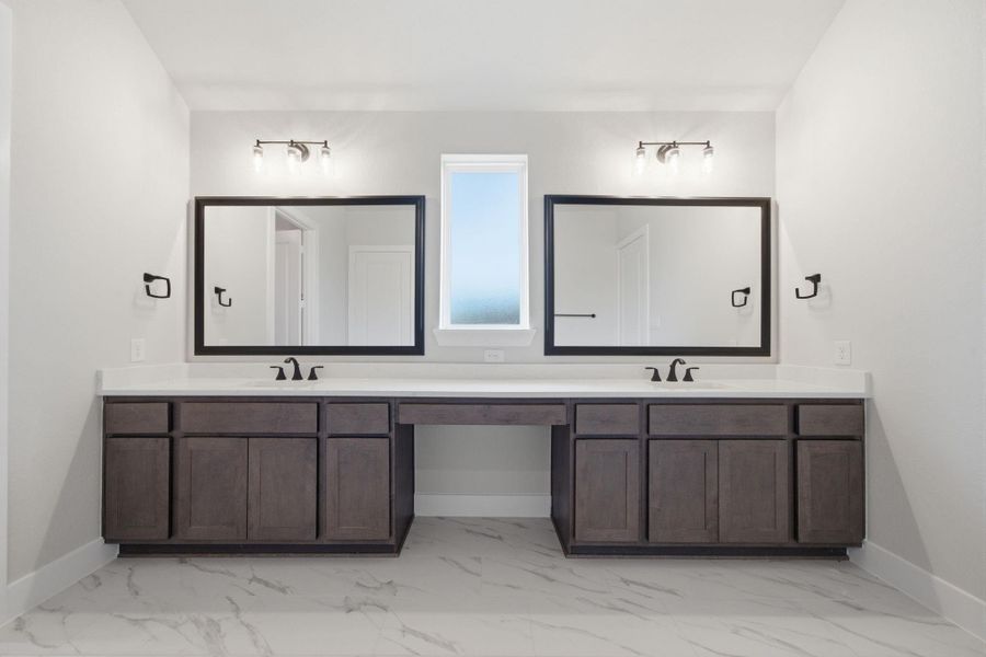 Spacious owner’s bath featuring dual vanities, generous counter space, and separate mirrors for added functionality.