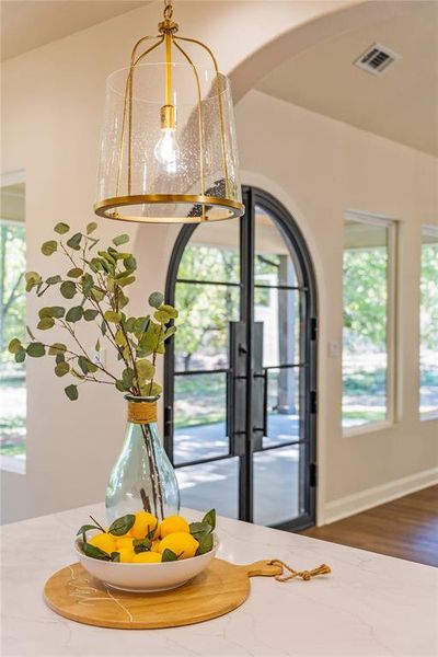 Detailed view of arched walkways, french doors, and wood finished floors