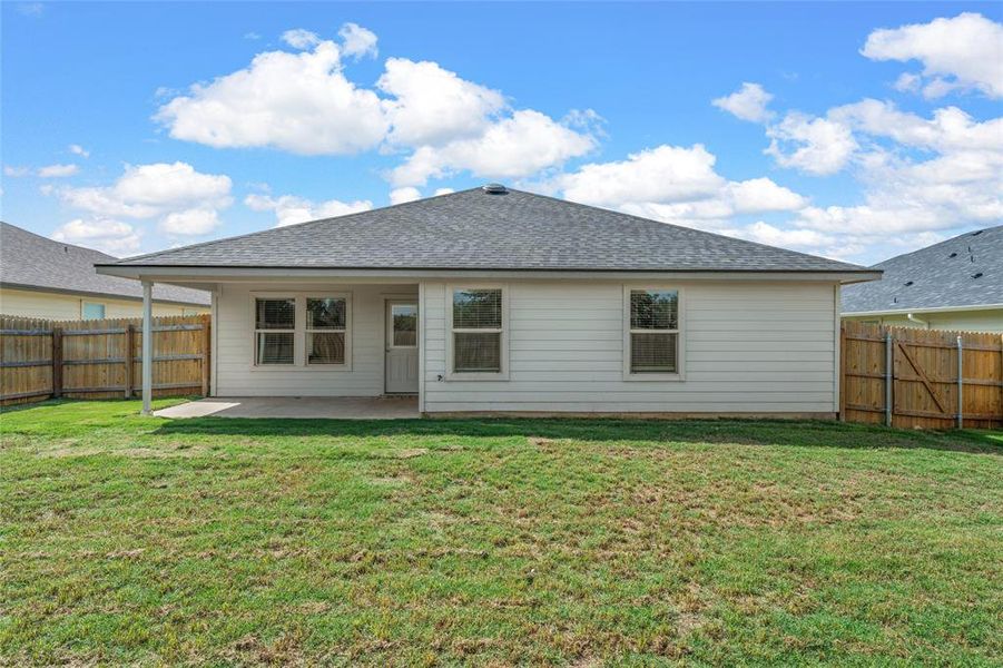 Back of property with a patio area, a fenced backyard, and roof with shingles Back of property with a patio area, a fenced backyard, and roof with shingles