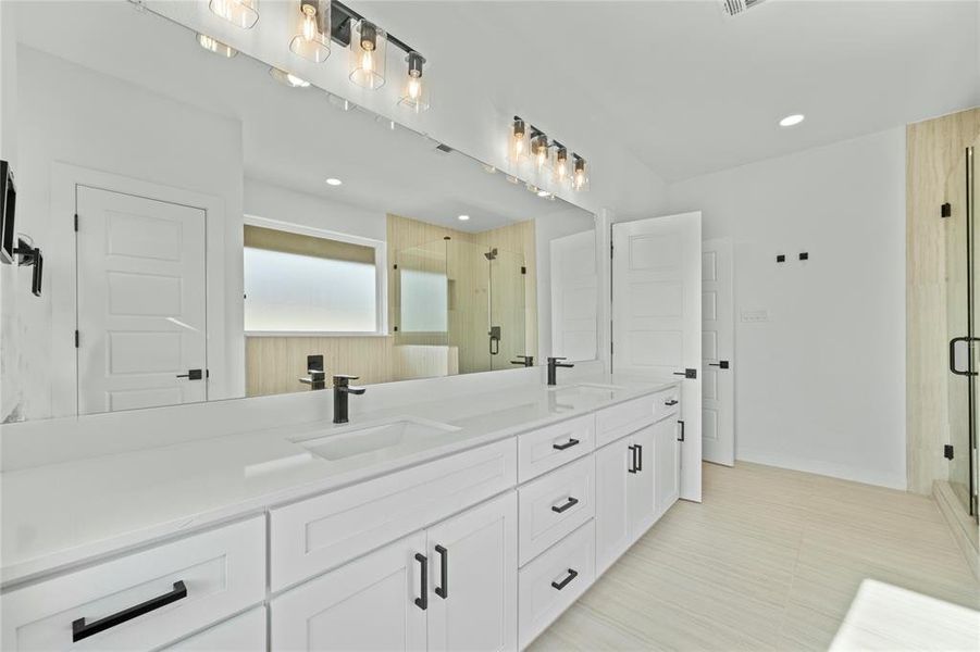 Bathroom featuring double vanity, a shower stall, and recessed lighting Bathroom featuring double vanity, a shower stall, and recessed lighting
