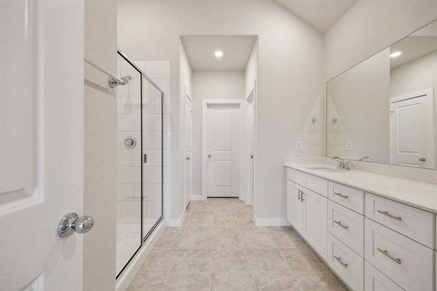 Bathroom featuring a shower, vanity and walk in closet